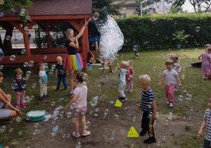 Pani tworzy ogromne banieczki dla wszystkich dzieci. Niedźwiadki z radością próbują je łapać.