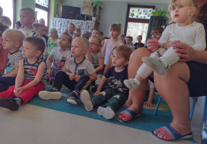 Niedźwiadki wraz z dziećmi z przedszkola z zaciekawieniem oglądające występ artysty.