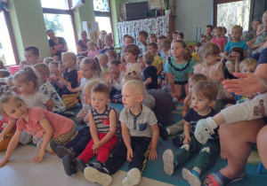 Niedźwiadki wraz z dziećmi z przedszkola z zaciekawieniem oglądające występ artysty.