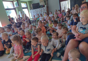 Niedźwiadki wraz z dziećmi z przedszkola z zaciekawieniem oglądające występ artysty.