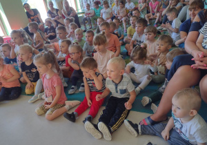 Niedźwiadki wraz z dziećmi z przedszkola z zaciekawieniem oglądające występ artysty.