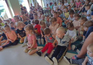 Niedźwiadki wraz z dziećmi z przedszkola z zaciekawieniem oglądające występ artysty.