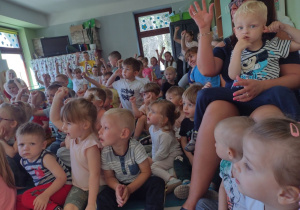 Niedźwiadki wraz z dziećmi z przedszkola z zaciekawieniem oglądające występ artysty.